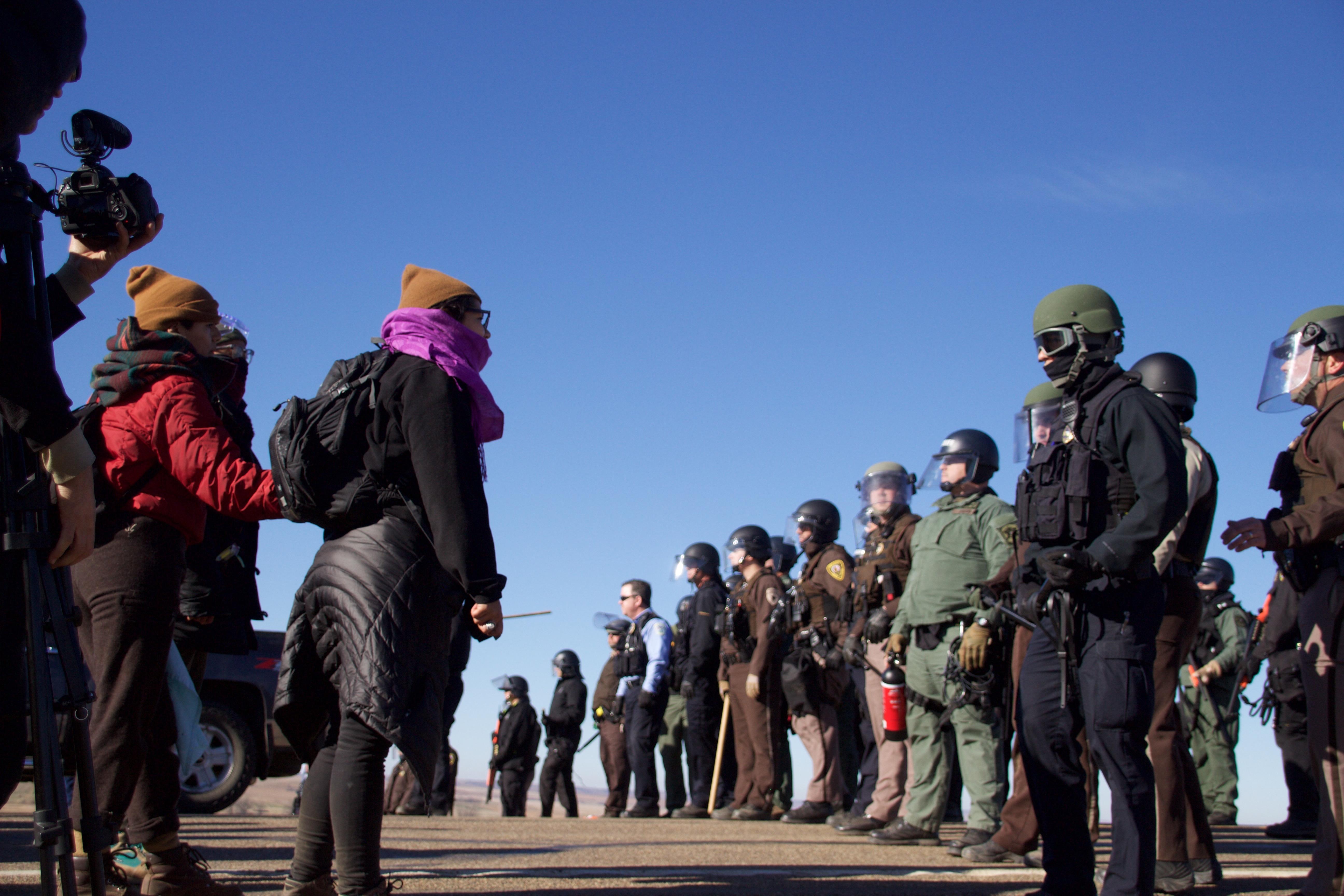 Pipeline opponents hold the line on Veteran's Day, 2016. At the camp, hundreds of Native American veterans marched as close as they could get to the pipeline construction site and prayed. Image Credit: Greg Harman