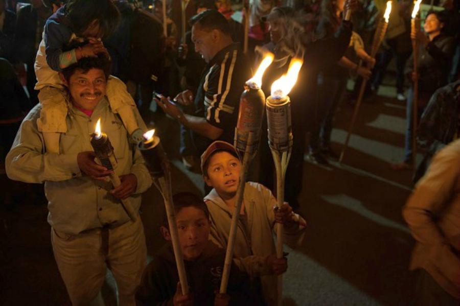 A child lights his brother’s torch during the march in memory of Berta Cáceres on March 2. Image: WNV/Jeff Abbott.